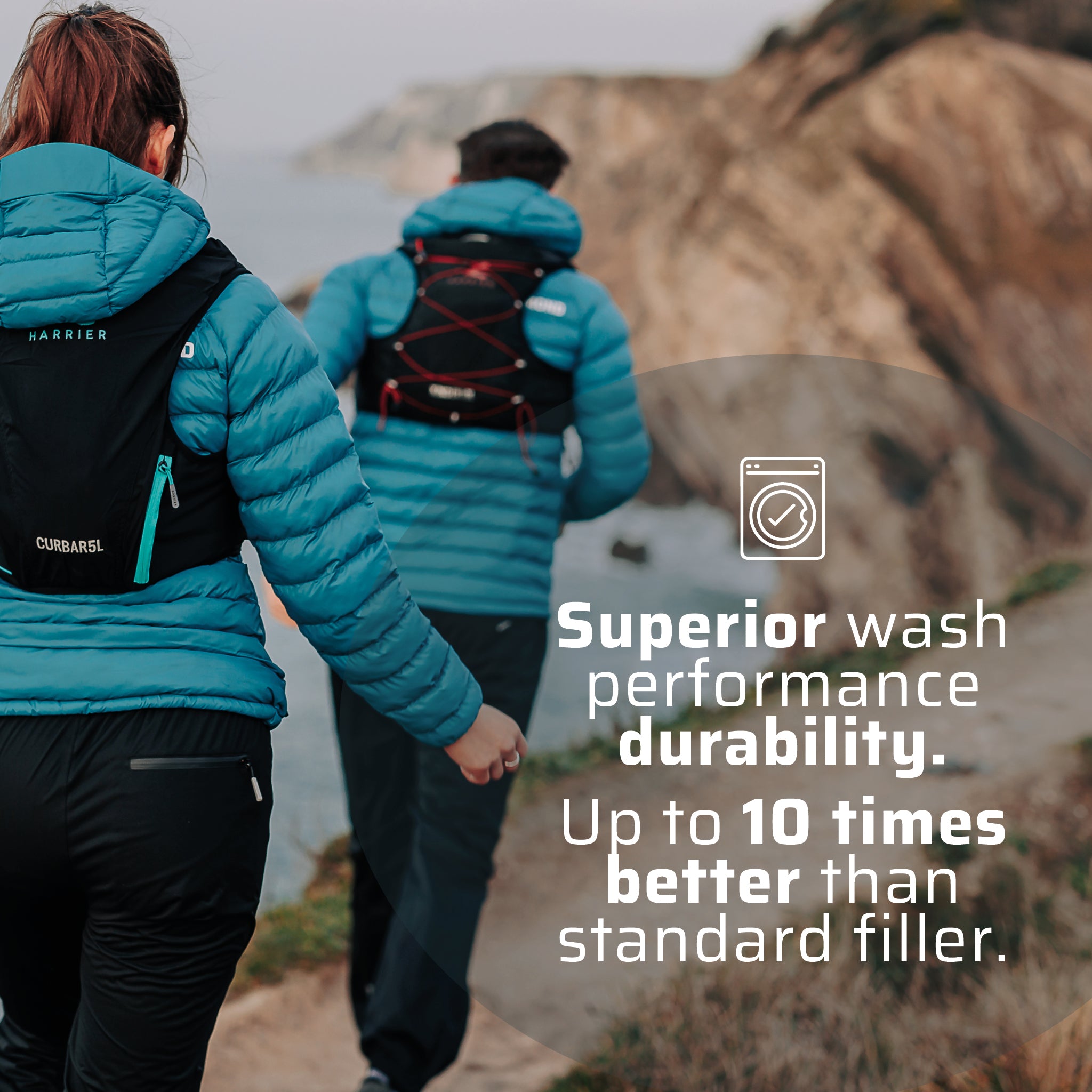 A man and a woman wearing the thermal jacket running along a coast line.