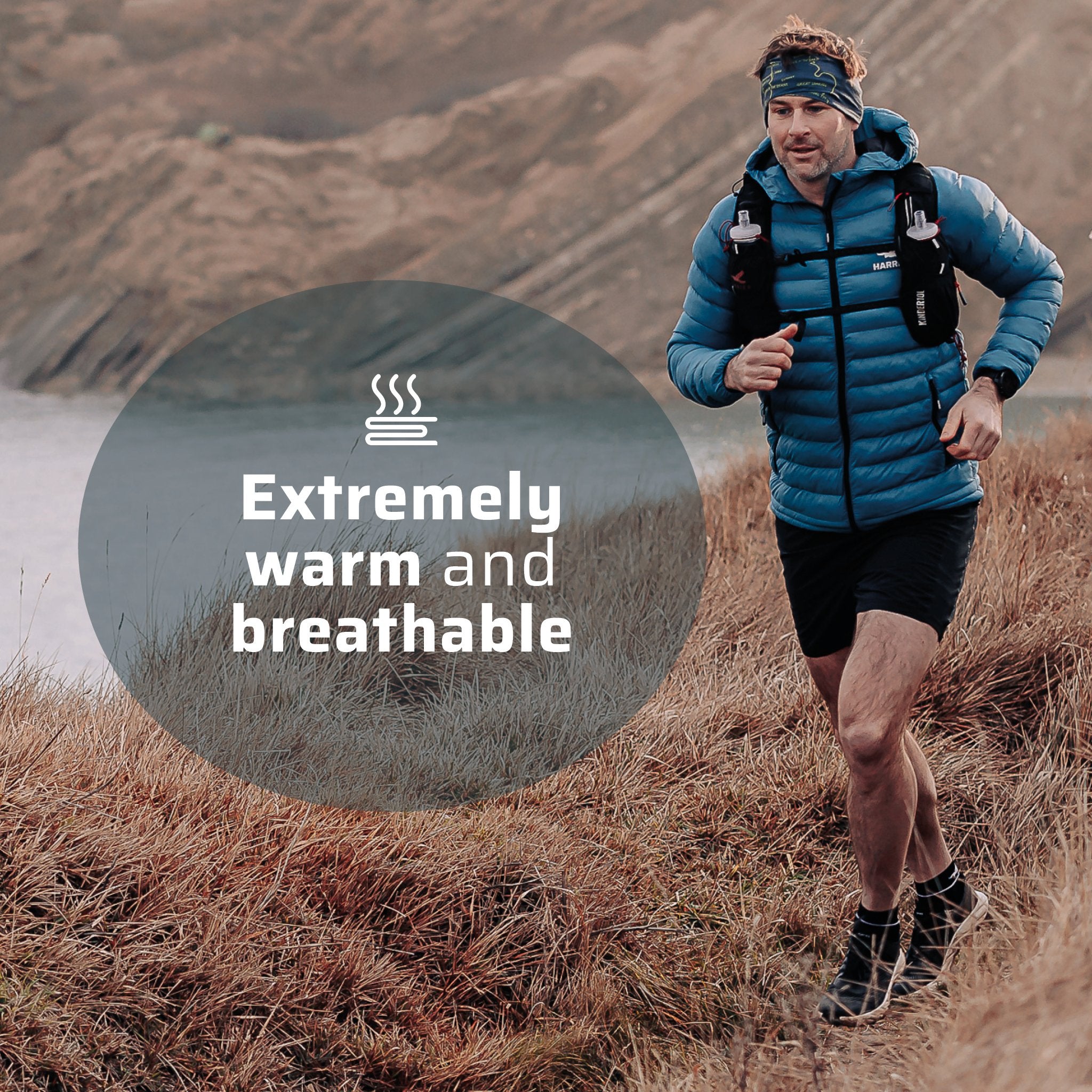 A man wearing the thermal jacket running along a coastline.