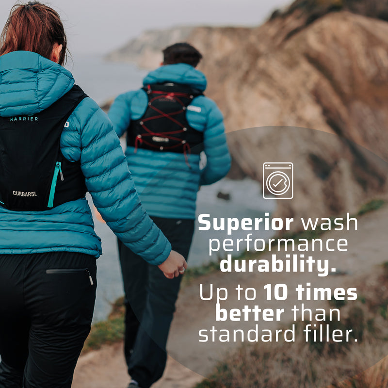 A man and a woman wearing the thermal jacket running along a coast line. 