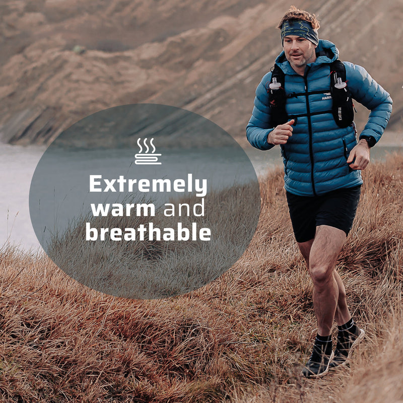 A man wearing the thermal jacket running along a coastline.