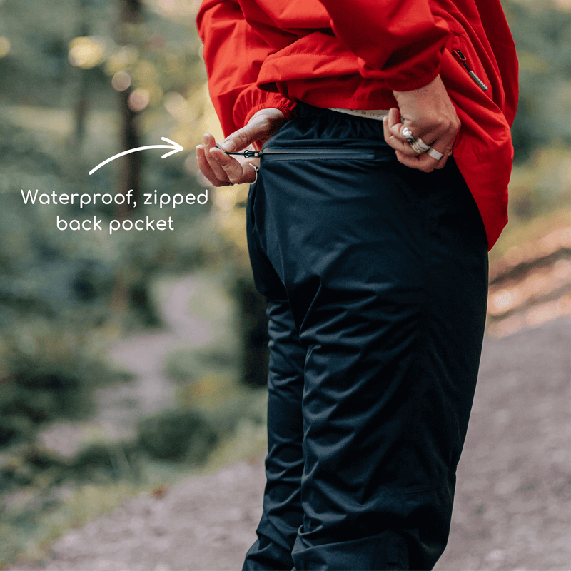 Close up of a person closing the zipped pocket on the rear of their waterproof trousers. 