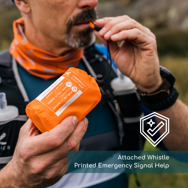 Man blowing the whistle attached to the survival bag. 
